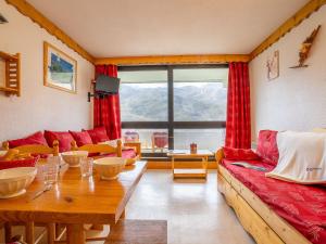 a living room with a red couch and a table at Apartment Brelin-5 by Interhome in Les Menuires