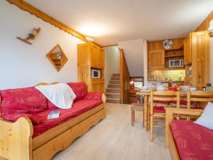 a living room with a red couch and a table at Apartment Brelin-5 by Interhome in Les Menuires