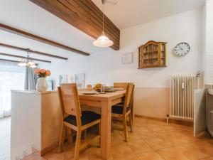 eine Küche mit einem Tisch und Stühlen sowie einer Uhr an der Wand in der Unterkunft Apartment Sepp by Interhome in Bad Hofgastein