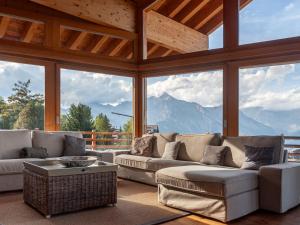 una sala de estar con sofás y vistas a las montañas. en Chalet Chalet Aquarius by Interhome, en Nendaz