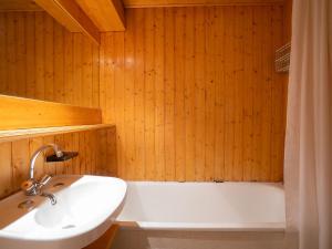 ein Badezimmer mit einem Waschbecken und einer Badewanne in der Unterkunft Apartment Belleville Caron-8 by Interhome in Les Menuires