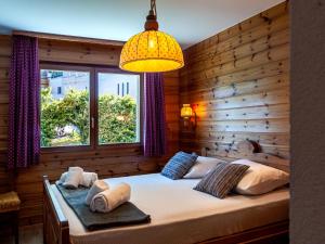 a bedroom with a bed with a wooden wall at Apartment Hauts De Nendaz B OP by Interhome in Nendaz