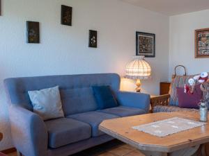 a living room with a blue couch and a table at Apartment Hauts De Nendaz B OP by Interhome in Nendaz
