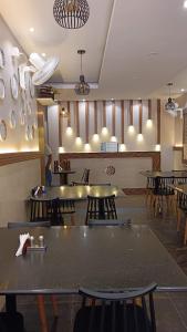 a restaurant with tables and chairs in a room at R-hotels Rithikha Inn porur in Chennai