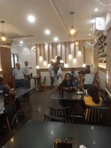 a group of people sitting at tables in a restaurant at R-hotels Rithikha Inn porur in Chennai