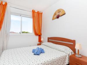 a bedroom with a bed with two blue towels on it at Apartment Florida by Interhome in Miami Platja
