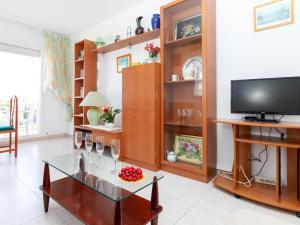 a living room with a tv and a glass table at Apartment Florida by Interhome in Miami Platja +15 photos