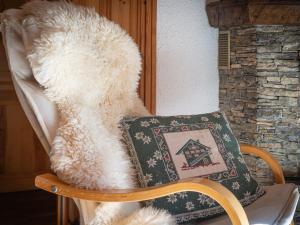 un orsacchiotto di peluche seduto su una sedia con una coperta di Apartment Le Mélèze by Interhome a Ovronnaz