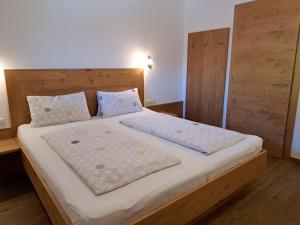 a bedroom with a large bed with white sheets and pillows at Apartment Anton-2 by Interhome in Ramsau im Zillertal