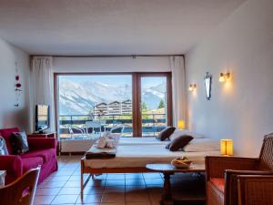 a bedroom with a large bed and a large window at Apartment Christiania 2 L1 by Interhome in Nendaz