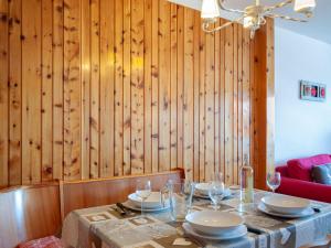 a dining room with a table with plates and wine glasses at Apartment Christiania 2 L1 by Interhome in Nendaz +26 photos