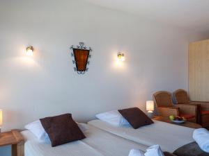 2 camas en una habitación con 2 lámparas en la pared en Apartment Christiania 2 L1 by Interhome, en Nendaz