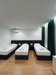 Cette chambre comprend 3 lits. dans l'établissement Clinton Tirana Inn, à Tirana