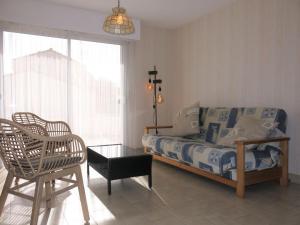 ラ・トランシュ・シュル・メールにあるHoliday Home Les Algues - TSM213 by Interhomeのベッドルーム1室(ベッド1台、椅子、テーブル付)
