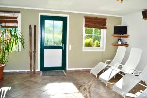 ein Wohnzimmer mit grüner Tür und weißen Stühlen in der Unterkunft Ferienstadl - Hammerau in Göstling an der Ybbs
