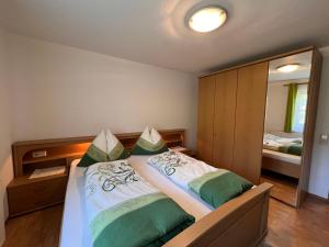 sypialnia z łóżkiem z zielonymi i białymi poduszkami w obiekcie Apartment Bauernhof Gasteg-3 by Interhome w mieście Piesendorf