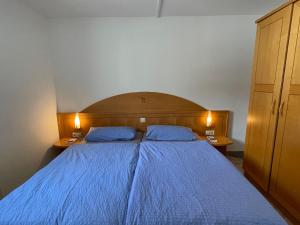 ベルナウ・イム・シュヴァルツヴァルトにあるApartment Schwarzwaldblick I by Interhomeのベッドルーム1室(青いベッド1台、青い枕2つ付)