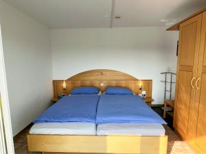 a bedroom with a large bed with a wooden headboard at Apartment Schwarzwaldblick I by Interhome in Bernau im Schwarzwald