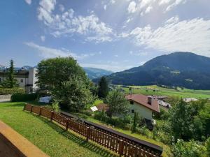 widok na dziedziniec z ogrodzeniem i góry w obiekcie Apartment Straif by Interhome w mieście Kirchberg in Tirol