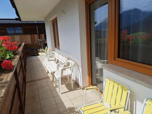 balkon z żółtymi krzesłami i oknem w obiekcie Apartment Straif by Interhome w mieście Kirchberg in Tirol