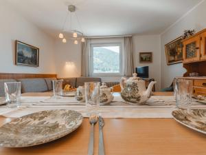 a dining room table with plates and vases on it at Apartment Martini by Interhome in Bad Gastein