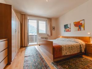 een slaapkamer met een bed en een groot raam bij Apartment Martini by Interhome in Bad Gastein
