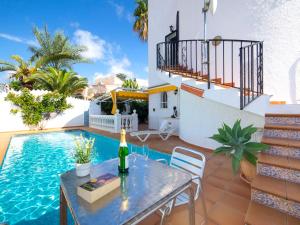 Villa con piscina y mesa con botella de vino en Holiday Home Casa de las Rosas by Interhome, en Alfaz del Pi