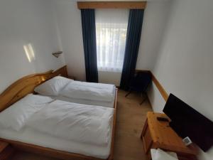 諾霍芬安德伊布斯的住宿－Neuhof，一间卧室配有一张床、一张书桌和一个窗户。