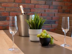 ノルトダイヒにあるHoliday Home Venusmuschel by Interhomeのワイングラス2杯と鉢植えのテーブル