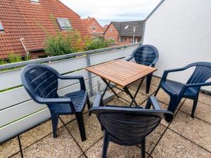 3 Stühle und ein Tisch auf dem Balkon in der Unterkunft Apartment Muschelweg-1 by Interhome in Norddeich