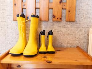 vier gelbe Regenstiefel auf einem Tisch in der Unterkunft Apartment Muschelweg-1 by Interhome in Norddeich