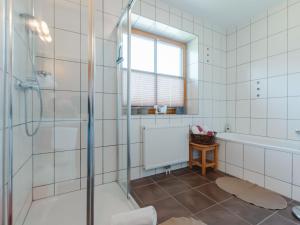 łazienka z prysznicem, wanną i oknem w obiekcie Holiday Home Erlachhof by Interhome w mieście Niedernsill