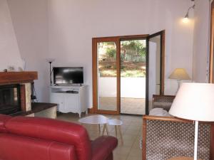 een woonkamer met een rode bank en een tv bij Holiday Home Les Bars - TSM507 by Interhome in La Tranche-sur-Mer