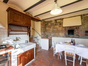 Una cocina con una mesa con sillas y una estufa. en Holiday Home Tenuta Farneta by Interhome, en Lucignano
