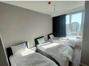 a hotel room with two beds and a window at luxury family 2+1 apt in toya next Residence in Istanbul