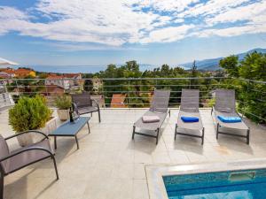 a patio with chairs and a swimming pool on a roof at Apartment Bella Vista - OPA102 by Interhome in Jurdani