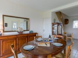 - une salle à manger avec une table en bois et un miroir dans l'établissement Holiday Home Mer des Bosmen 2 - LCQ107 by Interhome, au Conquet