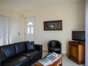 - un salon avec un canapé en cuir noir et une table dans l'établissement Holiday Home Mer des Bosmen 2 - LCQ107 by Interhome, au Conquet