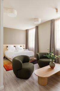 um quarto com uma cama, 2 cadeiras e uma mesa em Gogaille - Gambetta - accès autonome em Limoges