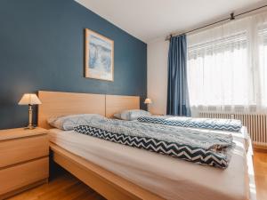 a bedroom with a large bed with blue walls at Apartment Haus Reitl VII by Interhome in Bad Gastein