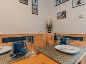 uma mesa de madeira com pratos e copos em Apartment Haus Reitl VII by Interhome em Bad Gastein