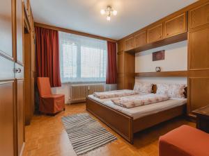een slaapkamer met een bed en een stoel erin bij Apartment Haus Reitl VII by Interhome in Bad Gastein