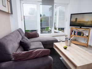 a living room with a couch and a table at Holiday Home Seefalke by Interhome in Norddeich
