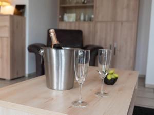 a bottle of champagne in a bucket and two wine glasses at Holiday Home Seefalke by Interhome in Norddeich