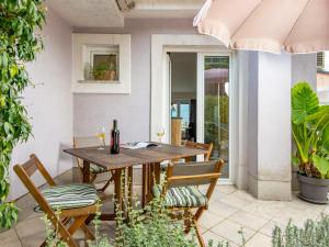 a patio with a wooden table and chairs at Apartment Bella Vista - OPA101 by Interhome in Jurdani