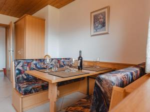 ケーニヒスライテンにあるApartment Voithofer-4 by Interhomeのテーブル(ワイングラス付)、ソファが備わる客室です。