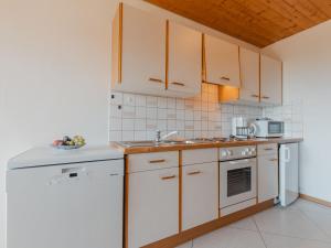 a kitchen with white cabinets and a sink at Apartment Voithofer-4 by Interhome in Königsleiten