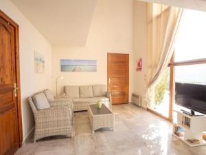 a living room with a couch and chairs and a tv at Holiday Home Le Belvédère by Interhome in Saint-Clair