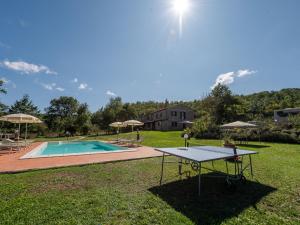 een tafeltennistafel in het gras naast een zwembad bij Holiday Home Alighiero II by Interhome in Gabellino