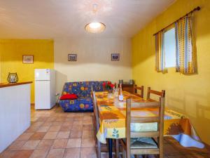 a dining room with a table and a couch at Holiday Home Lozard by Interhome in Barjac